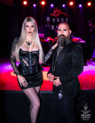 Two people posing on a stage with a 'House of Blues' sign in the background.